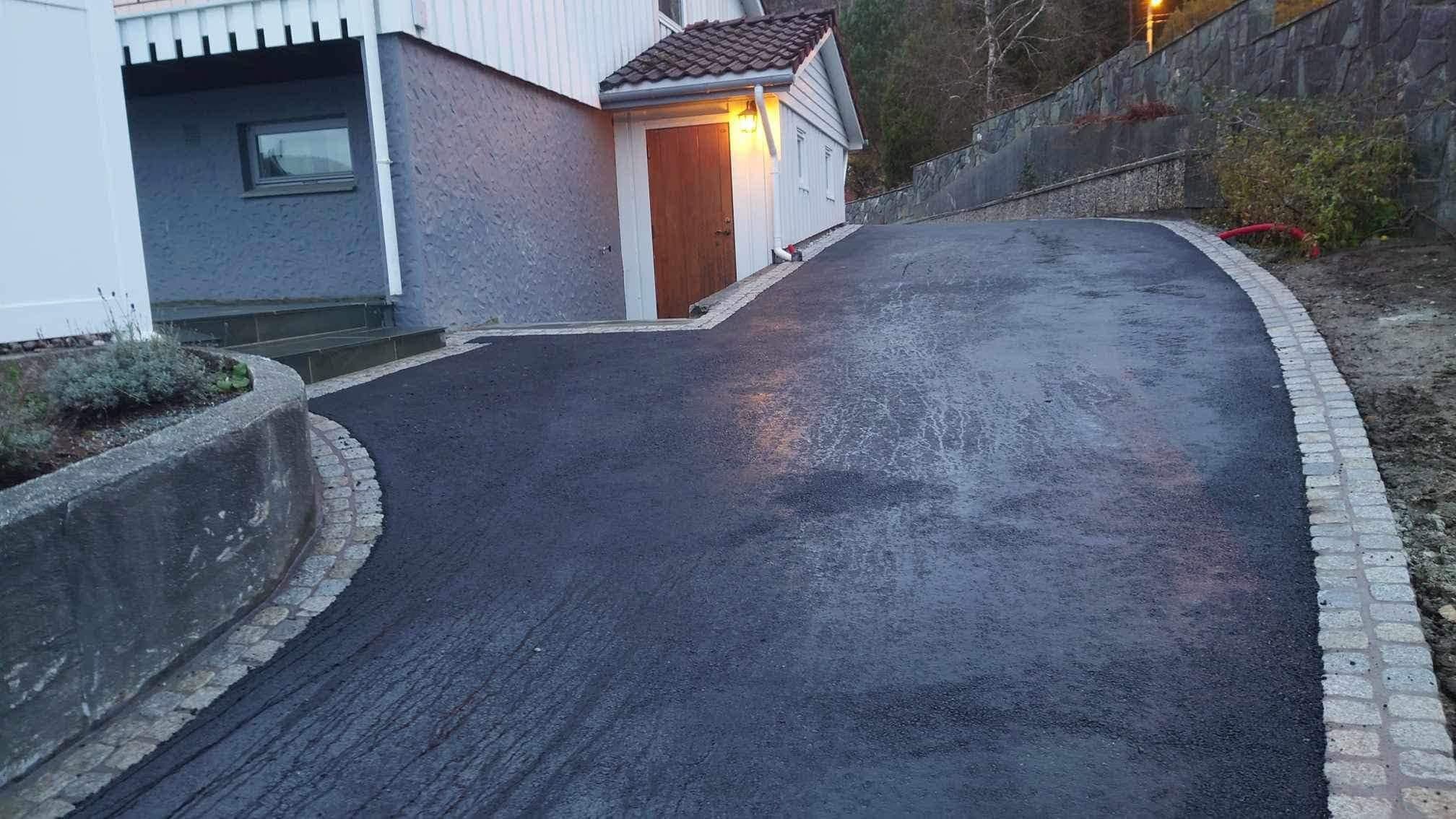 Asfalt med brosteinskanter og natursteinsmur ved hytta i Samnanger